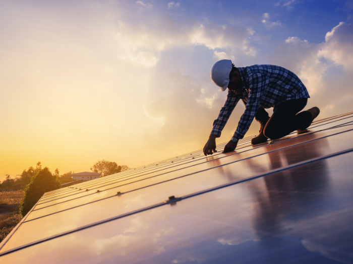 Construction worker installing solar panels