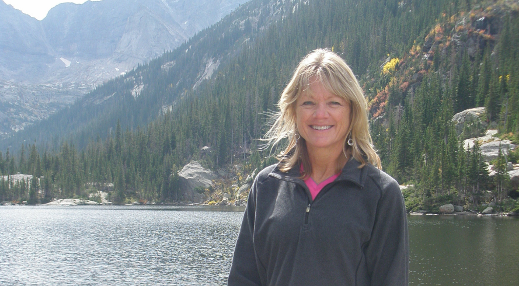 lauri-larson-standing-in-front-of-alpine-lake-on-a-sunny-fall-colorado-day