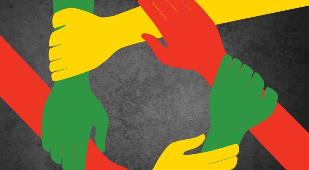 Yellow, green and red hands holding each other in a a circle
