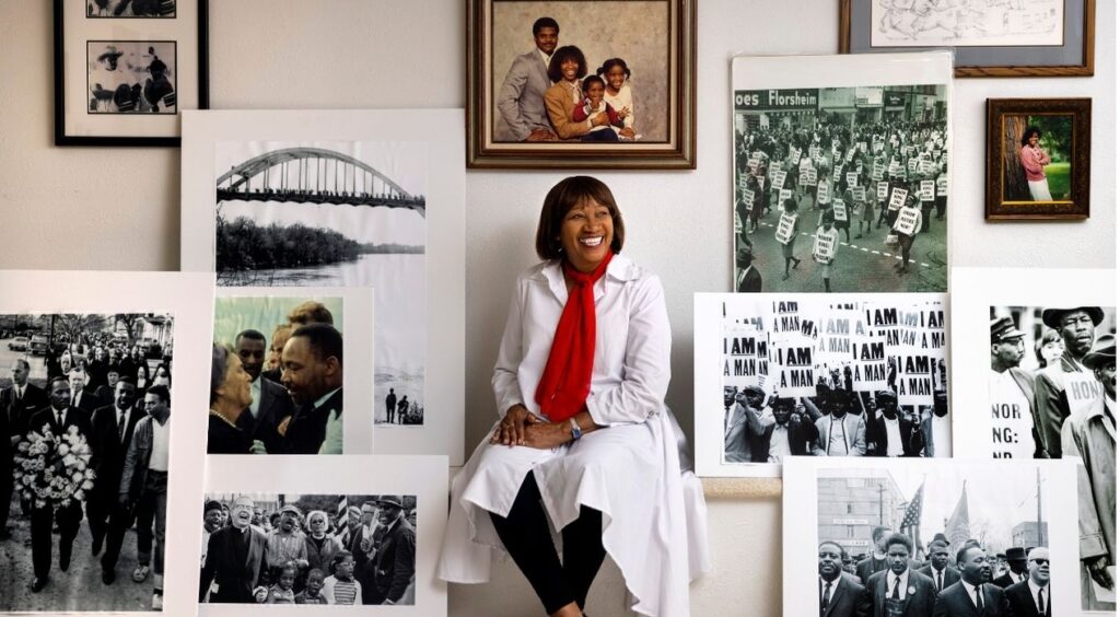 Glenda Robinson sitting with historical images from her march with Dr. Martin Luther King Jr.