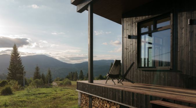 A distant mountain range in the background, a view of a modern cabin porch in the foreground