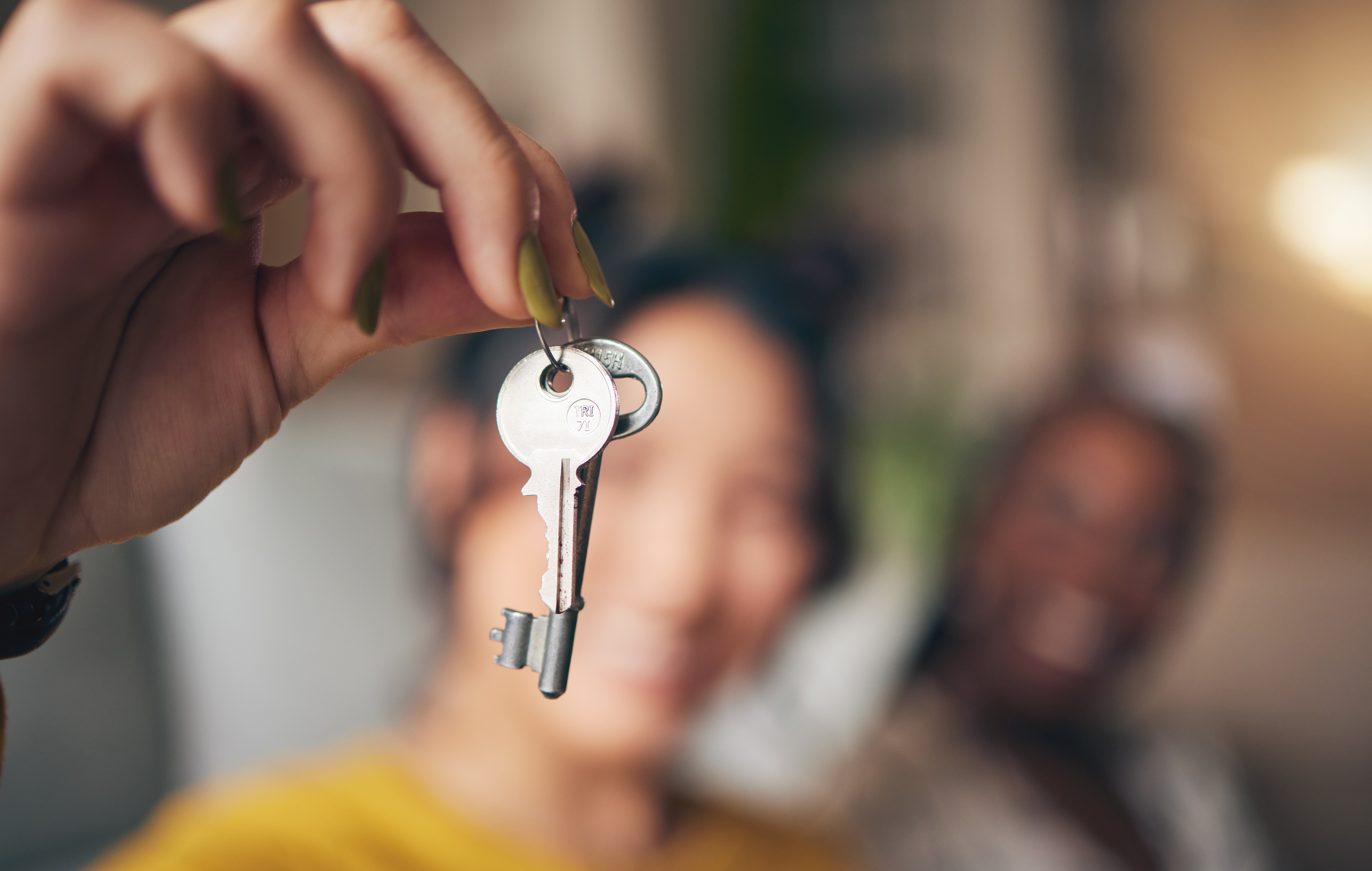New homeowners dangle keys and smile