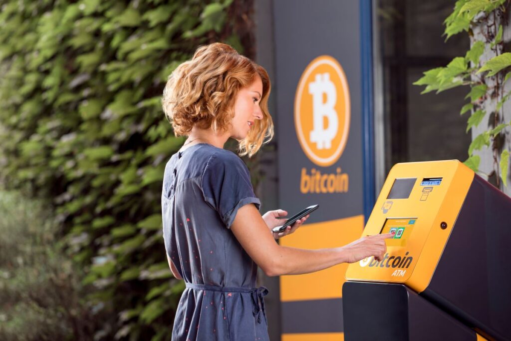 Woman withdrawing funds from bitcoin ATM